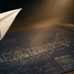 Paper airplane in flight over aircraft blueprints, representing testing ideas at small scale before full commitment